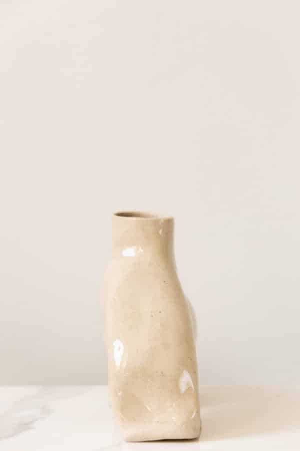 Large hand-built beige ceramic vase this is uniquely curved and a side view